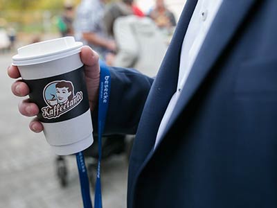 Besucher mit Kaffeebecher der Marke Kaffeetante auf einer NullVierNull Hausmesse